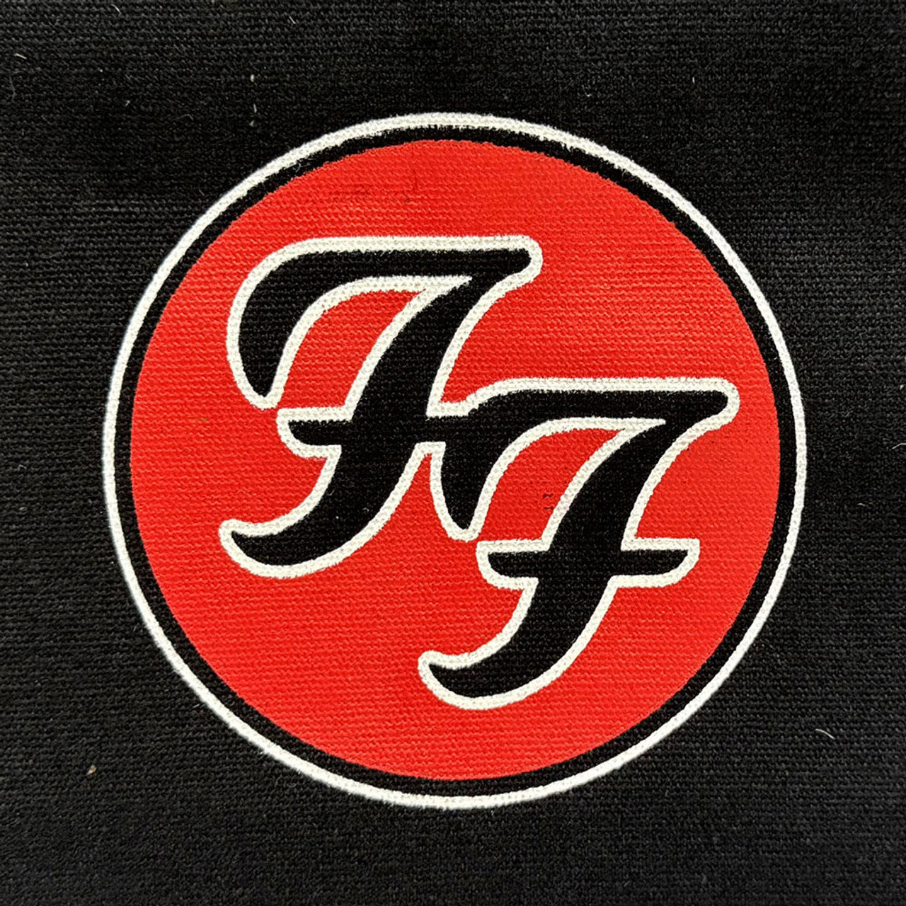 Close-up of Foo Fighters FF logo design printed on tote bag front.
